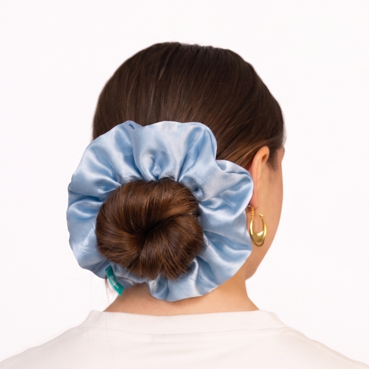 Powder blue oversized organic silk scrunchie wrapped around a low bun